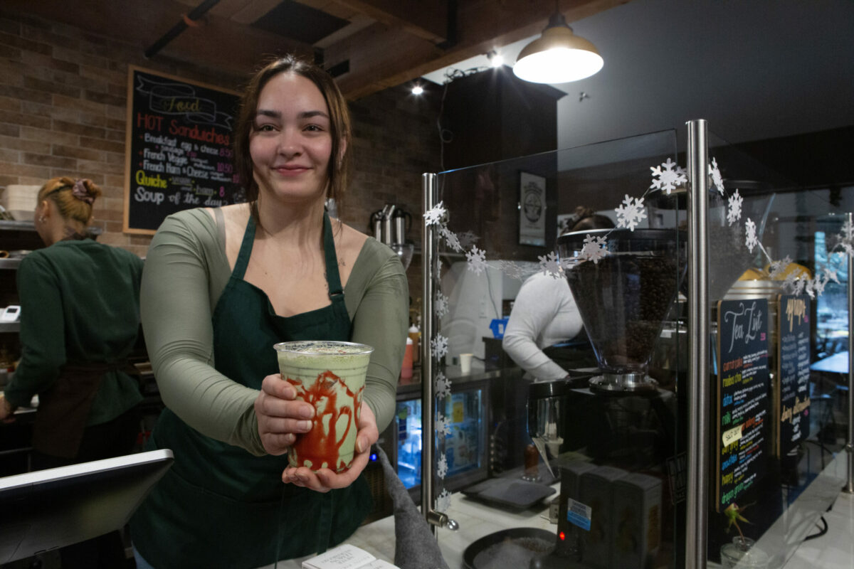 Team member Angie Eggers hands off a custom-made, iced strawberry-matcha beverage. Photo taken at Pilllowfight Coffee in Kenwood Village on Highway 12 on Friday, Dec. 13, 2024. (Robbi Pengelly / The Sonoma Index-Tribune)
