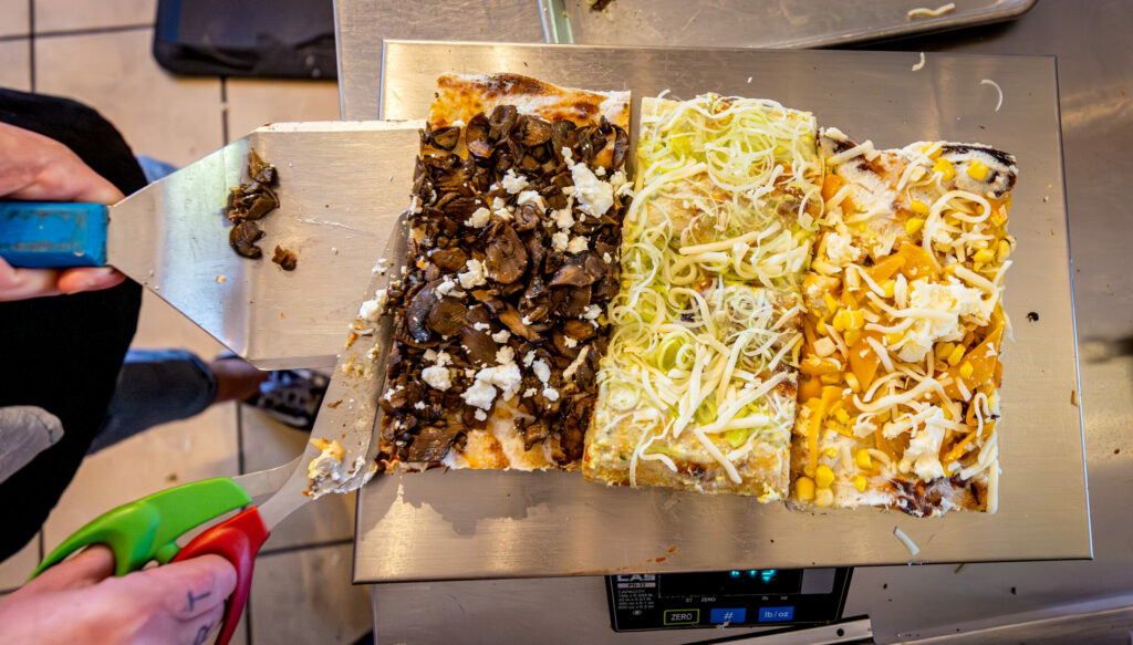 Roman-style sourdough pizzas are cut to length and sold by weight Thursday, September 25, 2025 at Psychic Pie in Sebastopol. (John Burgess / The Press Democrat)