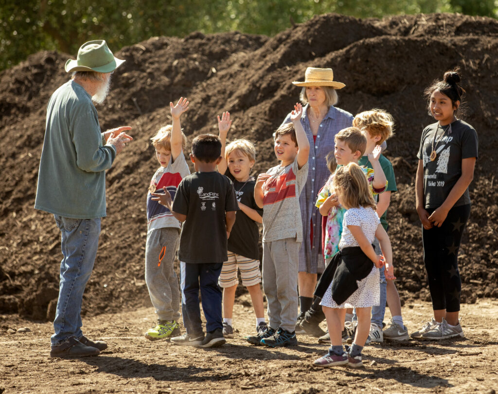 Susan, middle in hat, and Lou Preston talk about their compost pile during the LandPaths Owl camp at Preston Farm in the Dry Creek Valley in spring 2019. (John Burgess / The Press Democrat)