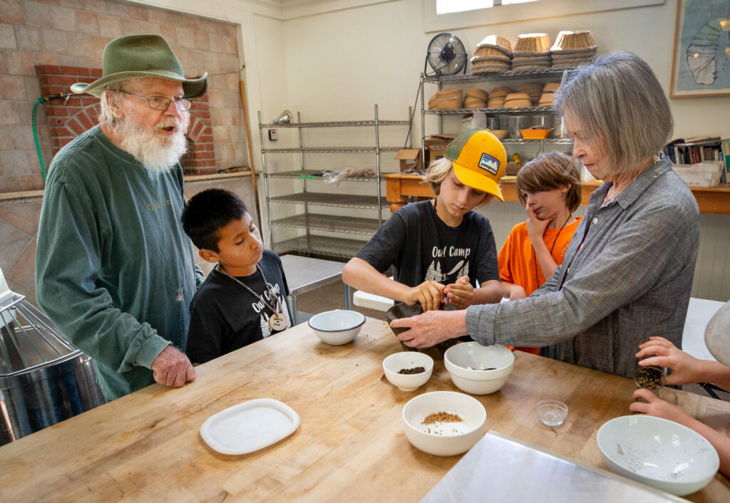 Susan, right, and Lou Preston show campers how to grind the spices for making sauerkraut during the LandPaths Owl camp at Preston Farm in the Dry Creek Valley in spring 2019. (John Burgess / The Press Democrat)