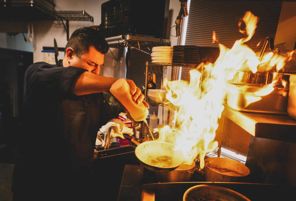 Chef Gus Vega cranks up the heat and great tastes in the tiny kitchen at the Grove Speakeasy Thursday, Oct. 9, 2025 in Penngrove. (John Burgess / The Press Democrat)