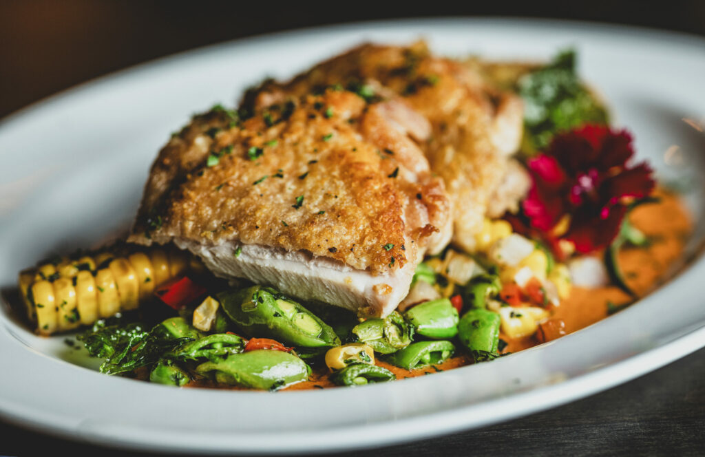 Chicken Corn Succotash with red pepper coulis, shallots, corn, snap peas and Mary’s chicken thighs at the Grove Speakeasy Thursday, Oct. 9, 2025 in Penngrove. (John Burgess / The Press Democrat)