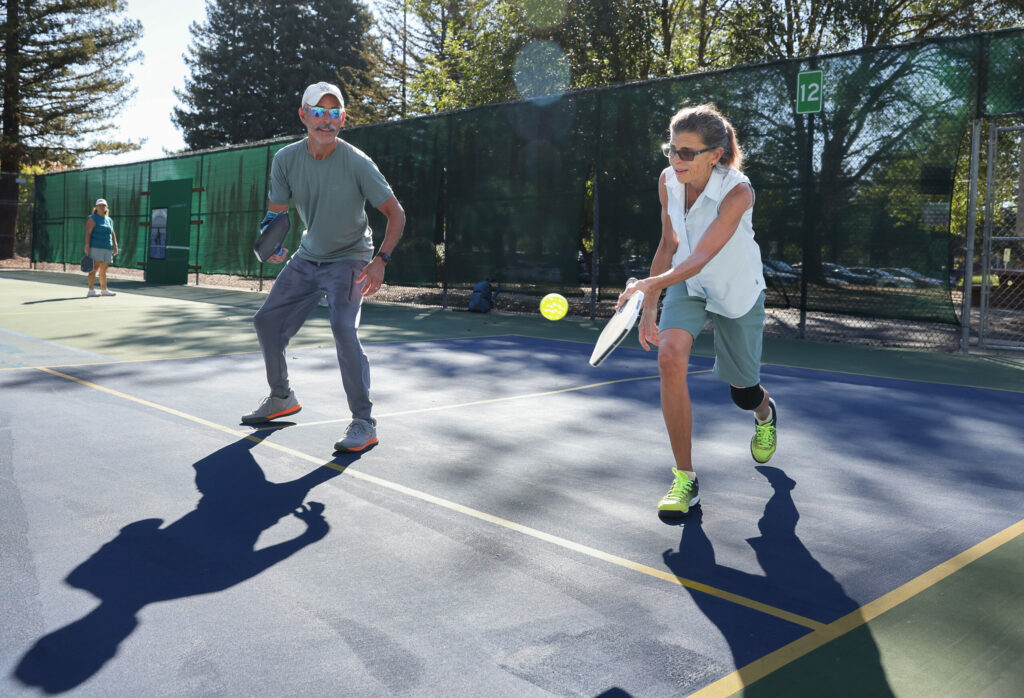 Terry Benezra, right, hits a ball while teaming up with Chris Rosales for a pickleball match at the Sunrise Park courts in Rohnert Park on Monday, October 6, 2025. (Christopher Chung / The Press Democrat)