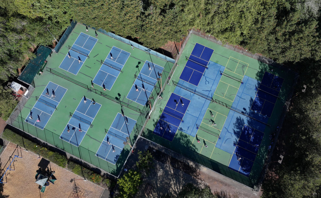 Pickleball players play on the 12 courts at Sunrise Park in Rohnert Park on Monday, October 6, 2025. Pickleball players raised more than thirty thousand dollars to convert two tennis courts into six additional pickleball courts, seen on the right. (Christopher Chung / The Press Democrat)
