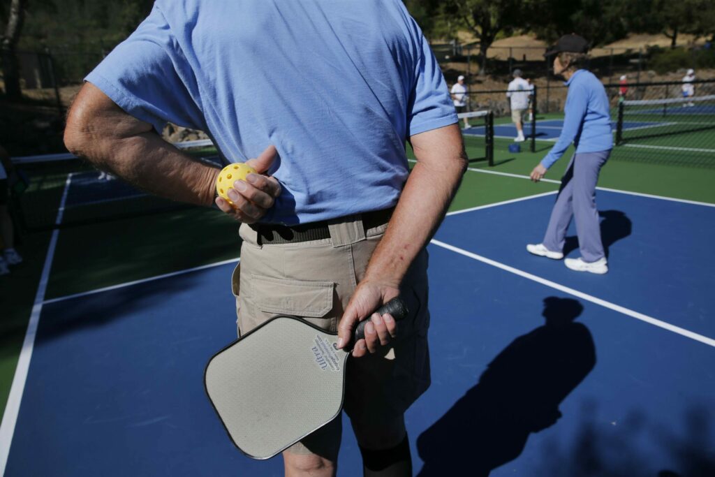 Gary Bunas holds a paddle and a wiffle ball before serving while playing pickleball on the new courts at the Oakmont East Recreation Center on Tuesday, June 12, 2018, in Santa Rosa. (Beth Schlanker / The Press Democrat)