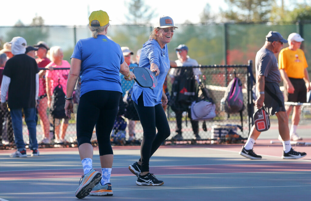 Carol Kovatch, right, and teammate Cheryl Heller congratulate each other after winning a point in pickleball at Finley Community Park in Santa Rosa on Wednesday, October 27, 2021. Pickleball players gathered at the courts to show the need for more pickleball courts. (Christopher Chung / The Press Democrat)