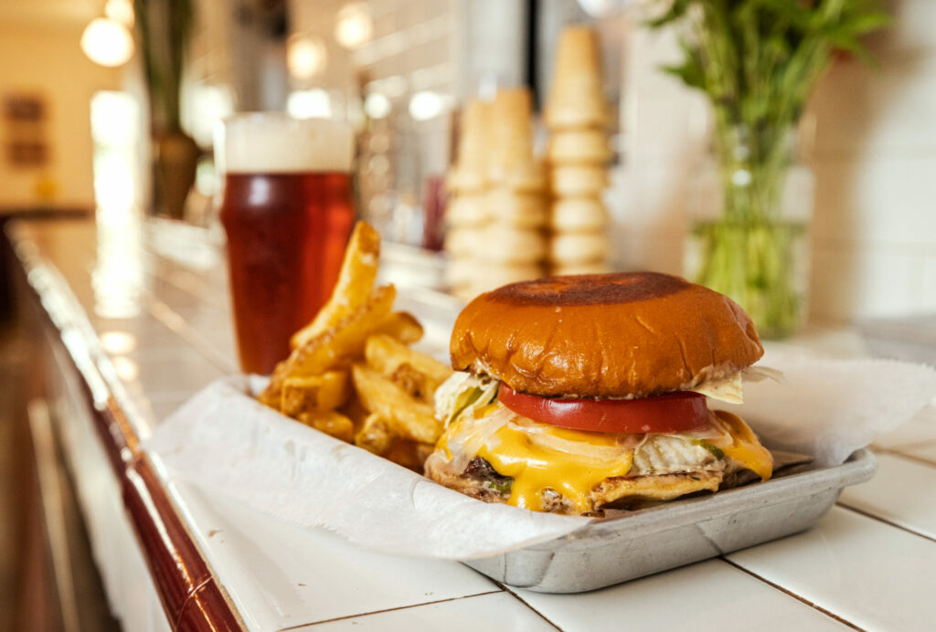 A Smash Burger and Fries with an Anderson Valley Boont Amber beer from Philo’s hot new restaurant, Jumbo’s Win Win Thursday, August 14, 2025. (John Burgess / The Press Democrat)