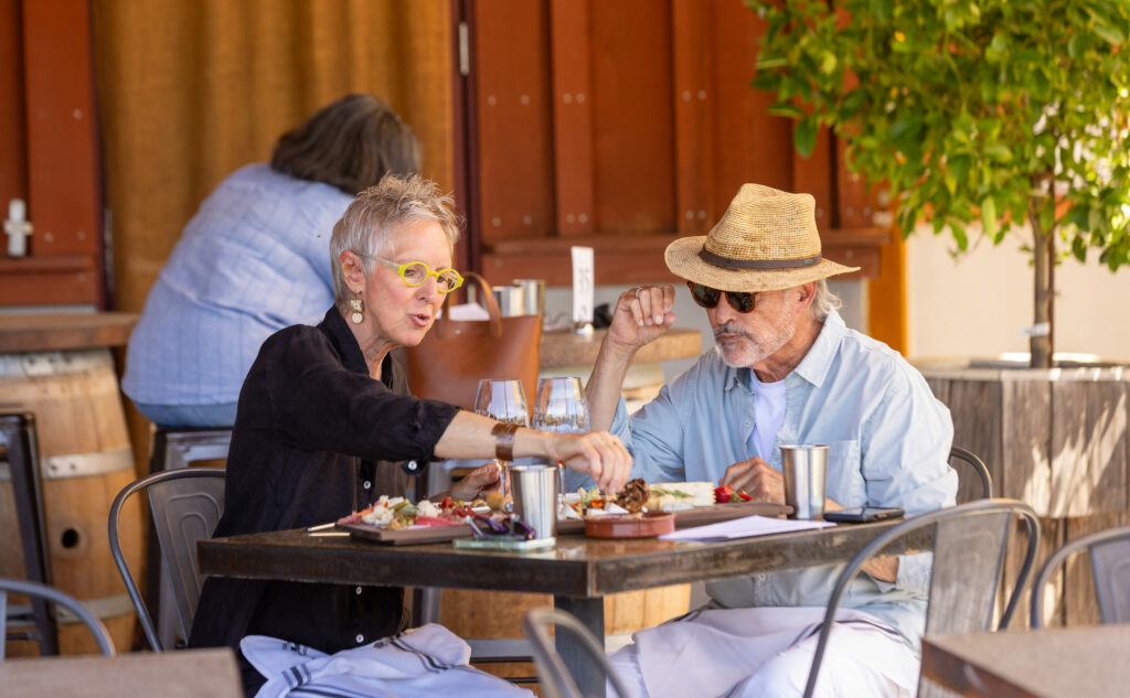 Peggy and Gary Deidrichs stopped for a cheese plate and a glass of wine at the bustling Pennyroyal Farm Thursday, August 14, 2025 in Booneville. (John Burgess / The Press Democrat)
