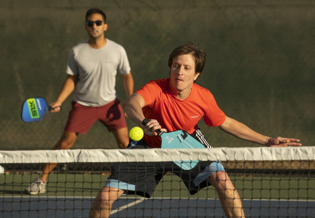 Trevor Landis, left, and John Malanga play in the regular Tuesday night pickleball game at Luchessi Park in Petaluma October 25, 2022. (John Burgess/The Press Democrat)