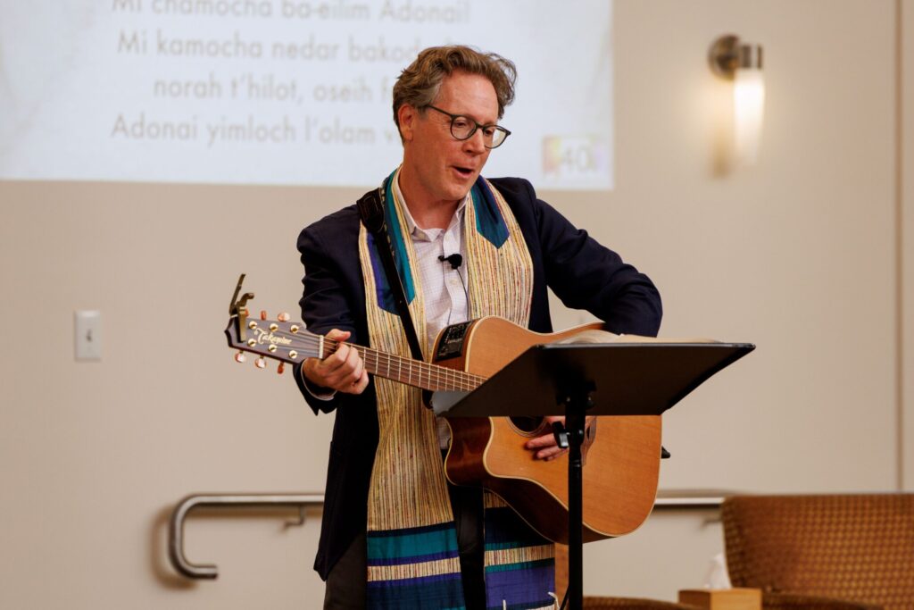 Rabbi Jeremy Morrison plays his guitar in front of his congregation during Shabbat at Congregation Shomrei Torah on August 15, 2025. (Abraham Fuentes/For The Press Democrat)