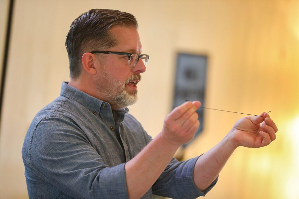 Robert Mahar holds up a thread while teaching his craft retreat at Westerbeke Ranch in Sonoma on Tuesday, September 16, 2025. (Christopher Chung/The Press Democrat)