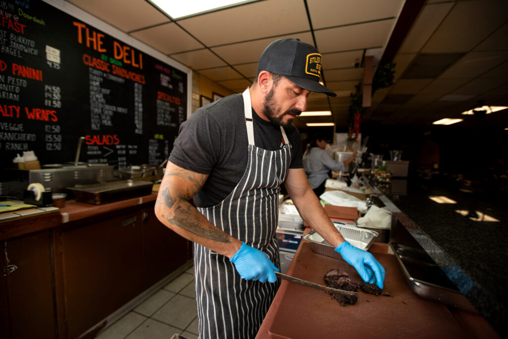 Bob Costarella, owner and pitmaster, cuts barbecued meat at his “Red Eye Barbecue” pop up, held on Saturdays at Sazon Peruvian Cuisine & Deli on November 15, 2025. (Darryl Bush / For The Press Democrat)
