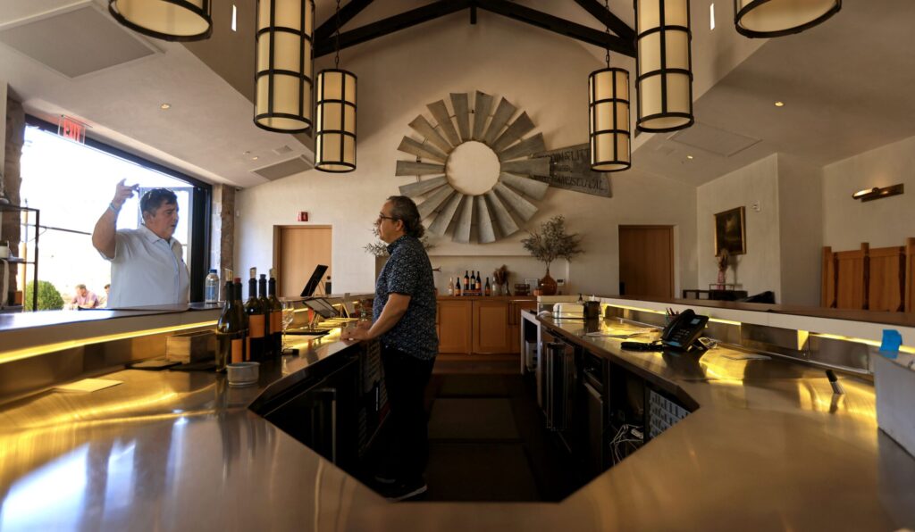 Inside the tasting room at Stewart Cellars, wine ambassador Manny Lopez, right, talks with Alex Grisanti from Mississippi, Friday, October 21, 2025, in Yountville. (Kent Porter / The Press Democrat)