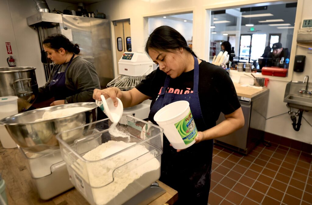 Cassidy Plata-Trejo, right, and Thida Vattanawase add ingredients to mix dough at Quail & Condor in Healdsburg, Thursday, Nov. 20, 2025. (Kent Porter / The Press Democrat)