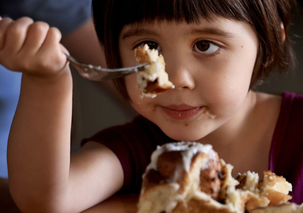 Charlotte Crabb, 4, considers the monumental task of consuming a pastry at Quail & Condor in Healdsburg, Thursday, Nov. 20, 2025. (Kent Porter / The Press Democrat)