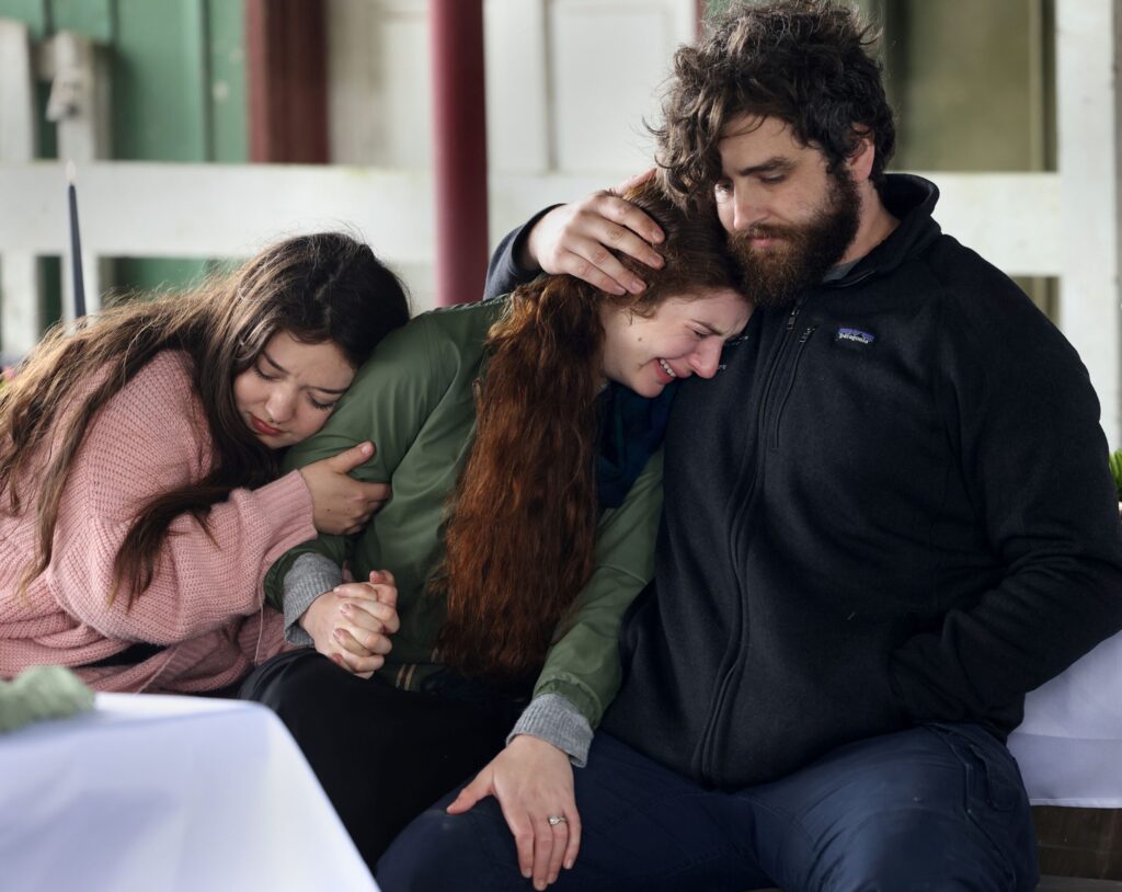 Rina Pringle, center, sister the late Katranne Pringle, is comforted by her husband David Harris and her friend Dani Sepulveda during a celebration of life event remembering Katranne Pringle at Tolay Lake Regional Park in Petaluma Sunday, March 30, 2025. (Beth Schlanker / The Press Democrat) 