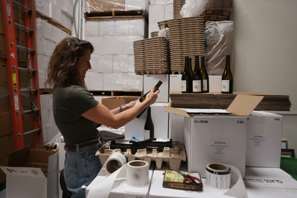 Madelyn Hille admires her handiwork while labeling bottles of her Schema Wines 2023 Cabernet Franc. (Beth Schlanker / for Sonoma Magazine)