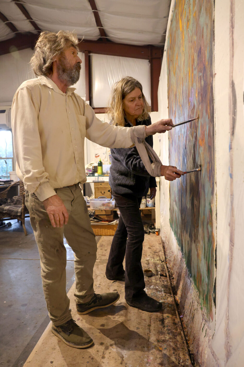 Artists Pamela Holmes and Winston Gourley paint with their arms bound together at Stranger Worth studio in Cazadero Thursday, Nov. 20, 2025. (Beth Schlanker / The Press Democrat)