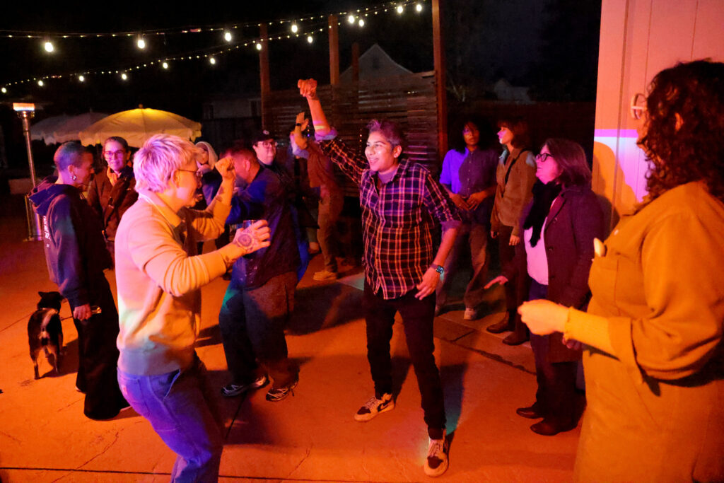 Chefs Dany Cleland, left, and Chef Preeti Mistry, center, dance during the Queer Soup Night event at Slow Co. Pizza in Cotati Sunday, Nov. 23, 2025. (Beth Schlanker / The Press Democrat)