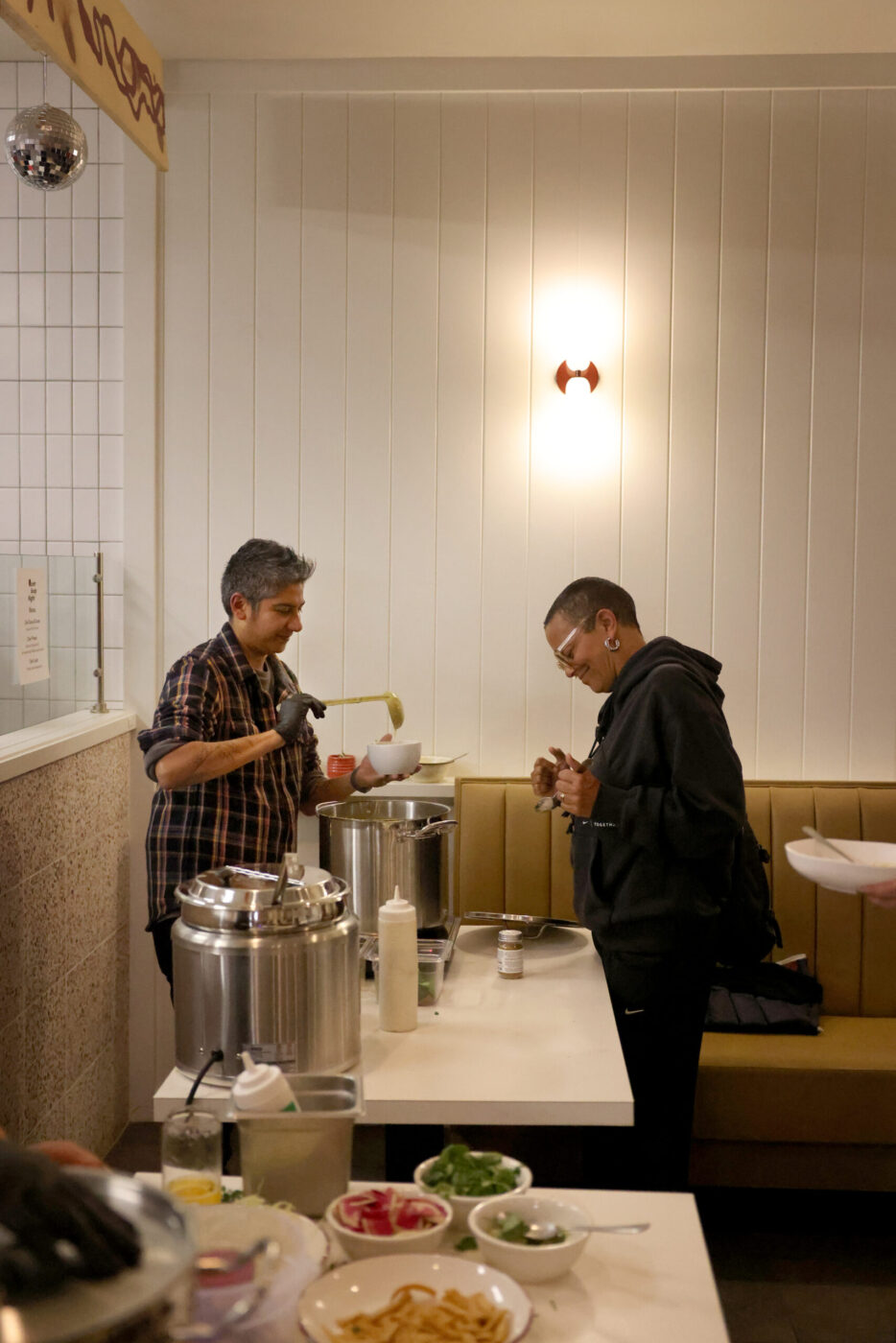 Chef Preeti Mistry, left, serves up a butternut squash dal soup during the Queer Soup Night event at Slow Co. Pizza in Cotati Sunday, Nov. 23, 2025. (Beth Schlanker / The Press Democrat)