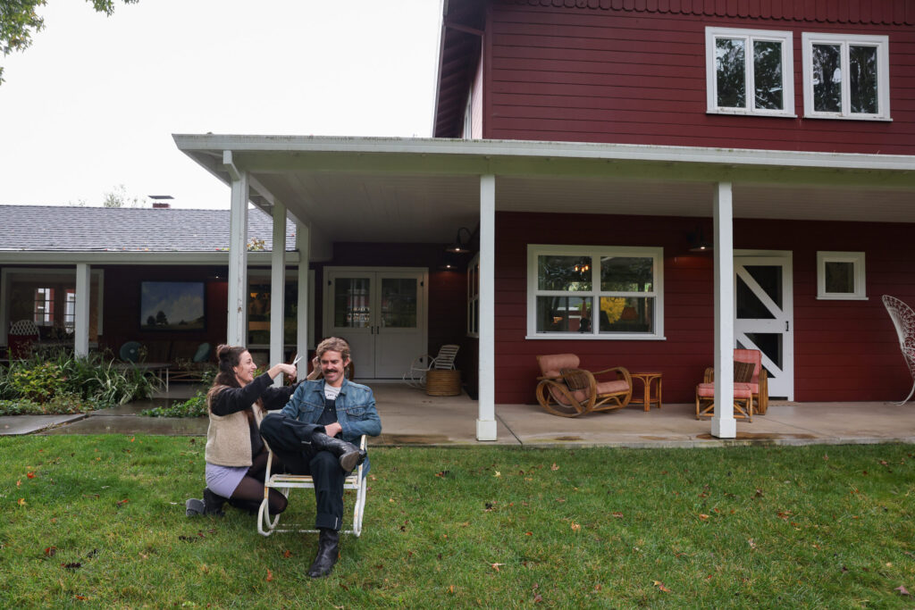 Desiree Cannon Doores, left, cuts her husband Sam Doores’ hair at the Little Saint Farm before their performance at Little Saint in Healdsburg on Thursday, November 13, 2025. Sam Doores is in the band The Deslondes. Desiree Cannon Doores, who performs under the name Desiree Cannon, is the opening act for the band. (Christopher Chung/The Press Democrat)