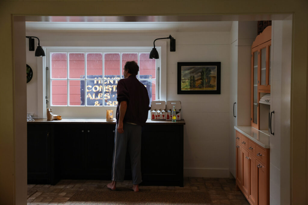 Howe Pearson, of The Deslondes, looks out at the rain while grabbing a snack from the kitchen at Little Saint Farm in Healdsburg on Thursday, November 13, 2025. (Christopher Chung/The Press Democrat)
