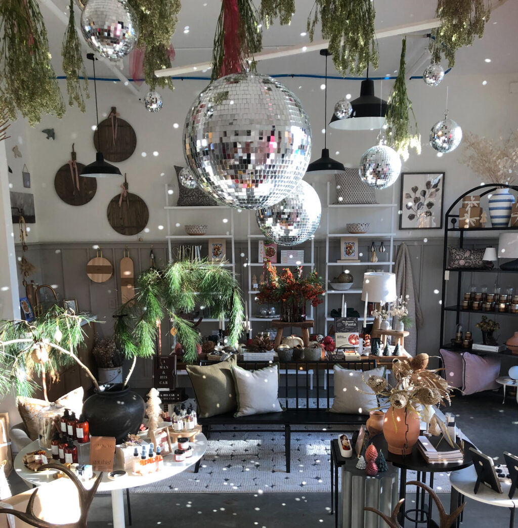 Disco balls have made their way to planters, pillows and more decor in recent years. Here they add some serious shimmer among traditional pine branches and red berries in Storia Home’s decor, by proprietor and interior designer Gina Gutierrez. (Storia Home)