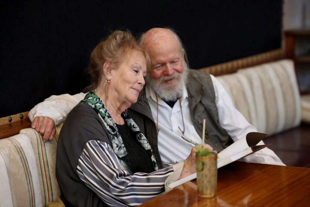 Artist Susan Preston, joined by her husband Lou, signs a copy of her book “In Ghost Time: The Art and Stories of Susan Preston” during a launch party for her book “In Ghost Time: The Art and Stories of Susan Preston” at Barndiva in Healdsburg Sunday, Sept. 14, 2025. (Beth Schlanker / The Press Democrat)