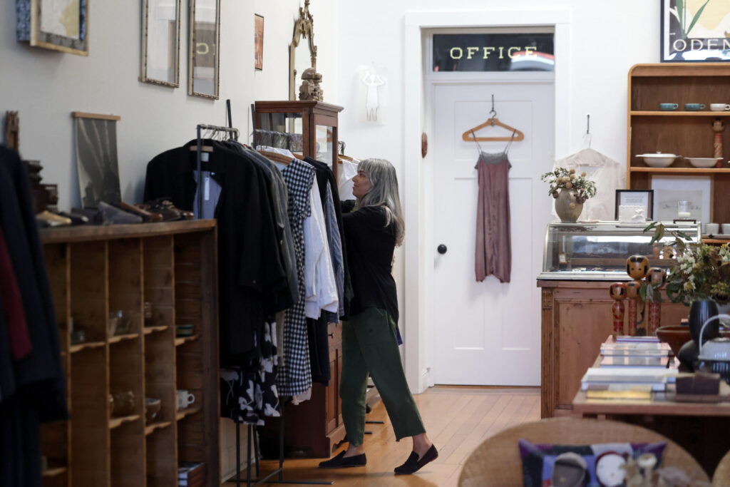 Jess Brown of Jess Brown Designs organizes a rack of clothes for sale in Petaluma Thursday, Sept. 18, 2025. (Beth Schlanker / The Press Democrat)