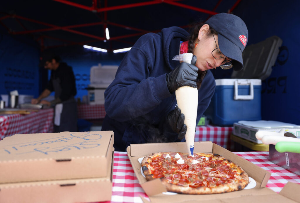 Michele Querin adds Bellwether Farms ricotta onto a “Giuseppe” pizza at the Gabacool Provisions pop-up in Santa Rosa on Thursday, January 30, 2025. (Christopher Chung/The Press Democrat)