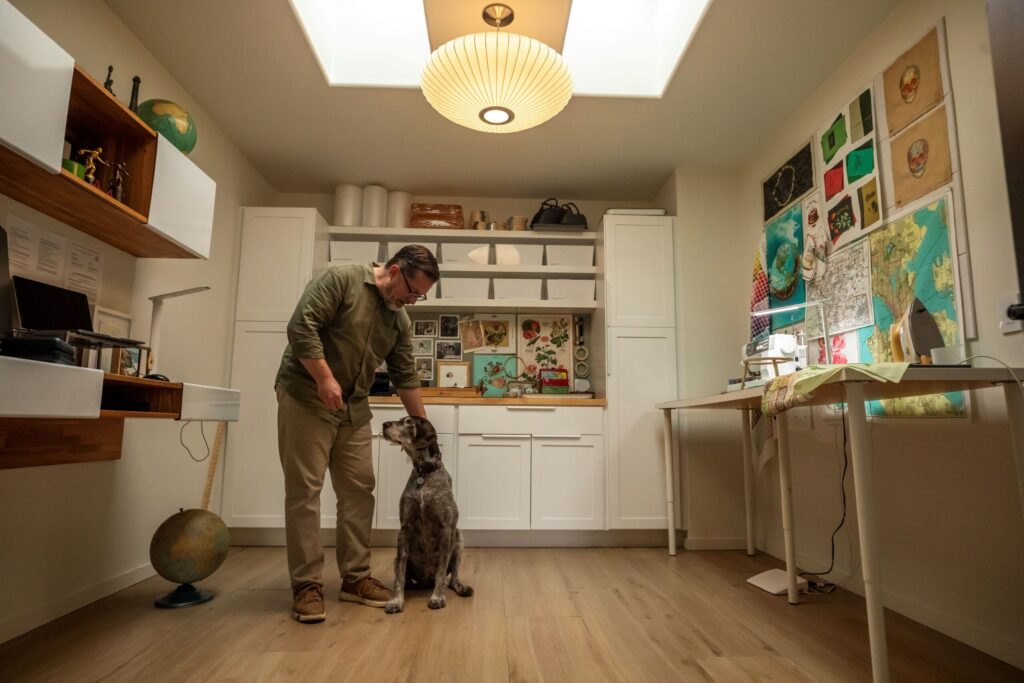 Embroidery artist Robert Mahar with his senior rescue dog, Bunny, a German wire-haired pointer, in his Wine Country home studio. (Chad Surmick / Sonoma Magazine)