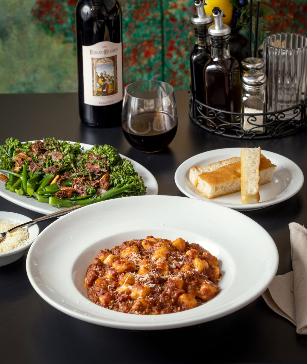 Gnocchi with Bolognese meat sauce, Broccolini alla bagna cauda and homemade focaccia bread on the creekside deck at Cafe Citti Thursday, February 22, 2024 in Santa Rosa. (John Burgess/The Press Democrat)