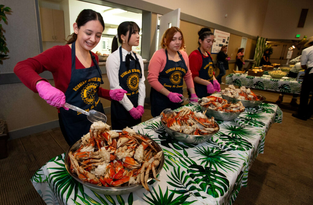 Volunteers from left, Andrea Benito Chino, Sara Ali, Lola Ortiz and Valentina Ortiz, all of Santa Rosa, prepare to dish out crab to guests during Russian River Rotary’s 37th annual crab feed at Friedman Events Center in Santa Rosa, Saturday, Jan. 20, 2024. (Darryl Bush / For The Press Democrat)