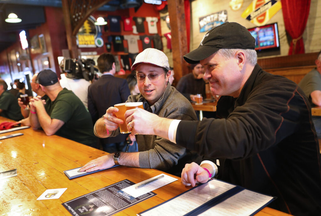 Craig McDermott, left, and Pete Schrankel, both of New Hampshire, toast their first glass of Pliny the Younger at the bar at Russian River Brewing Company, in Santa Rosa on Friday, February 2, 2018. (Christopher Chung / The Press Democrat)