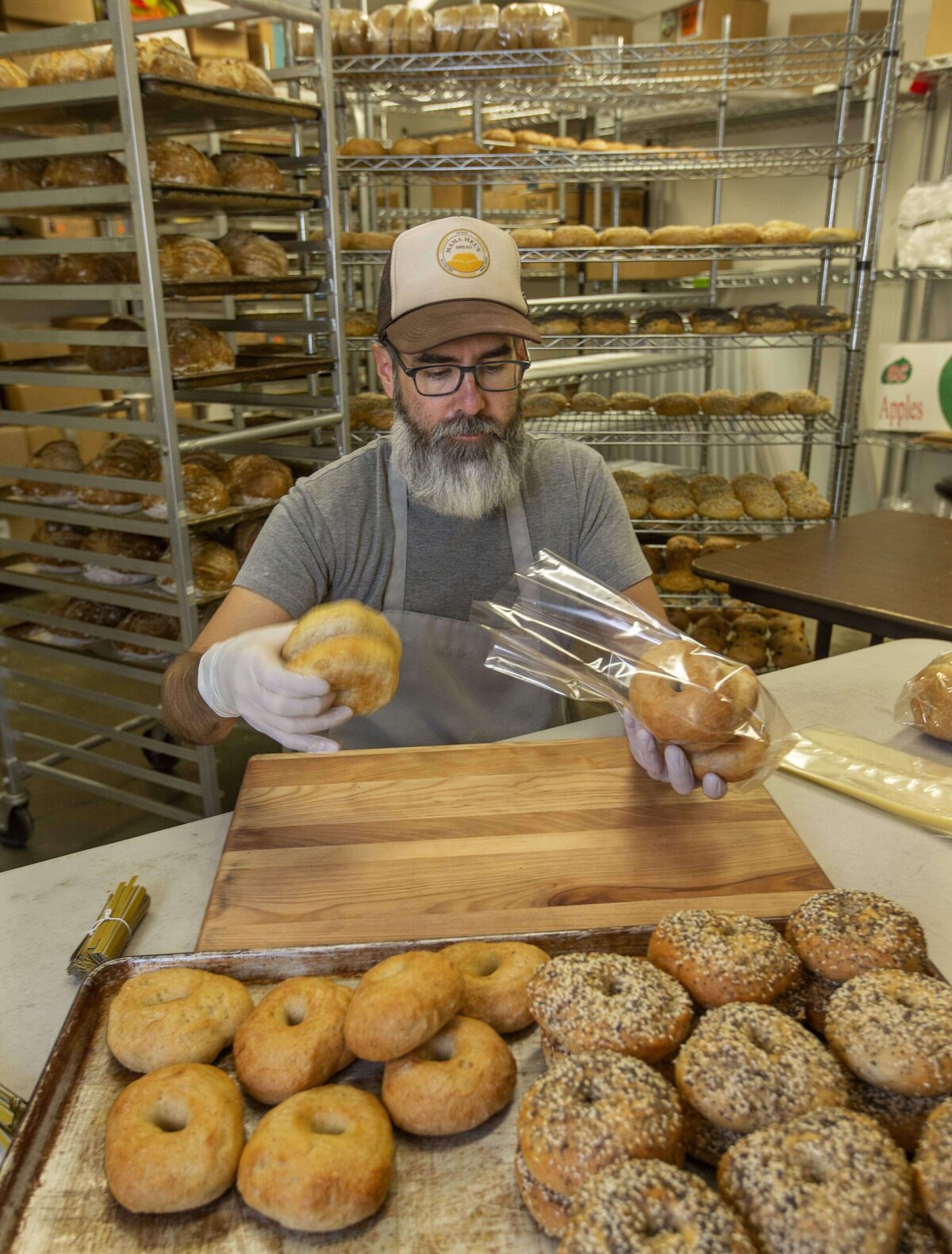 Thomas James packages fresh baked gluten-free bagels at Mama Mel's Bread in Petaluma in 2018. (John Burgess / The Press Democrat)