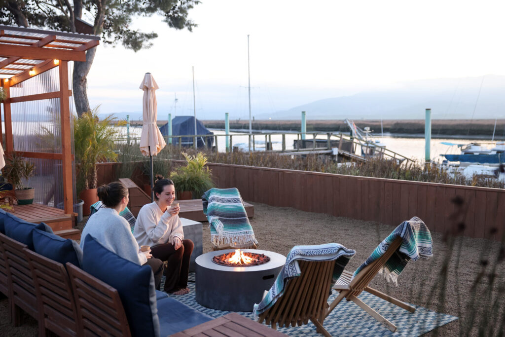 Friends Lucia Mora, right, and Renee Rodgers relax by the fire at Sundrop Sauna in Petaluma Sunday, Nov. 30, 2025. (Beth Schlanker / The Press Democrat)
