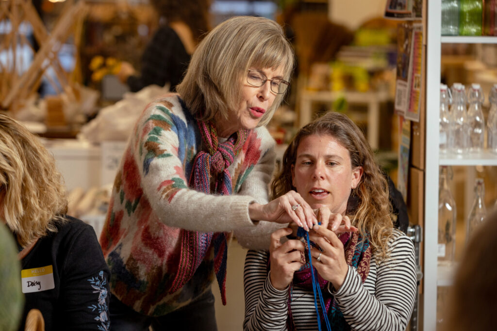 Instructor Pam Marshall, left, shows Daisy Wurtz how to create the pattern used to make a pair of felted slippers during a class Tuesday Dec. 2, 2025 at Gather in Sebastopol. (John Burgess / The Press Democrat)