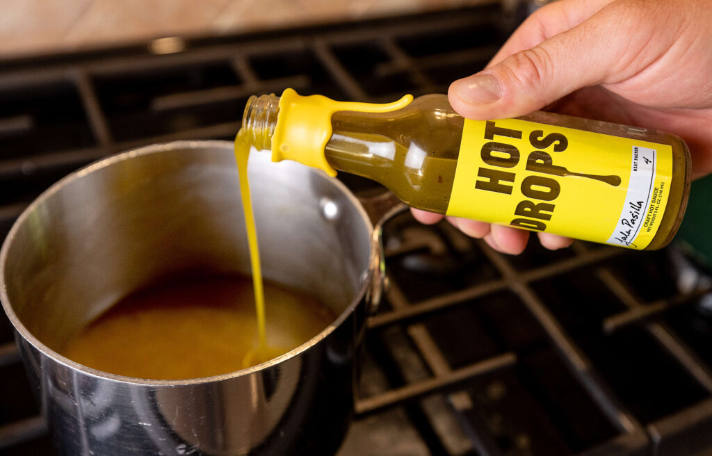 Andrew Whiting, owner of Hot Drops hot sauce and recent finalists on Gordon Ramsay's Food Stars, uses his premium facto-fermented Fres-Yes sauce in his Caesar Salad dressing Wednesday, August 7, 2024 in Santa Rosa. (John Burgess/The Press Democrat)