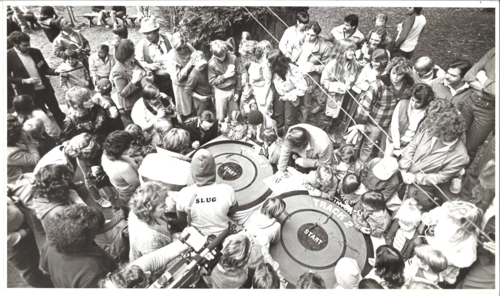 Spectators and entrants gather around the two ‘race tracks’ used to race slugs at the Russian River’s annual Slug Fest on March 17, 1985. Slugs are placed in the center and the first to exit the outer ring wins. (Mark Aronoff / The Press Democrat)