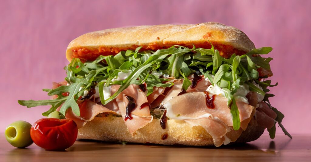 The Regina with prosciutto, stracciatella, herb relish, roasted tomato spread, arugula and balsamic glaze on a ciabatta from Genero’s Deli Friday, Jan. 30, 2026 in Sebastopol’s Barlow district. (John Burgess/The Press Democrat)