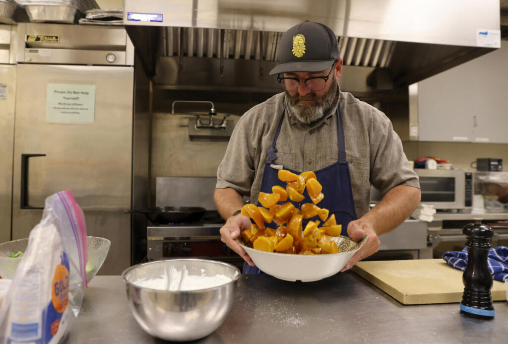 Chef Joshua Schwartz tosses golden beets with salt and pepper during a Hannukah cooking class at Congregation Shomrei Torah in Santa Rosa, Sunday, December 4, 2022. (Beth Schlanker/The Press Democrat)