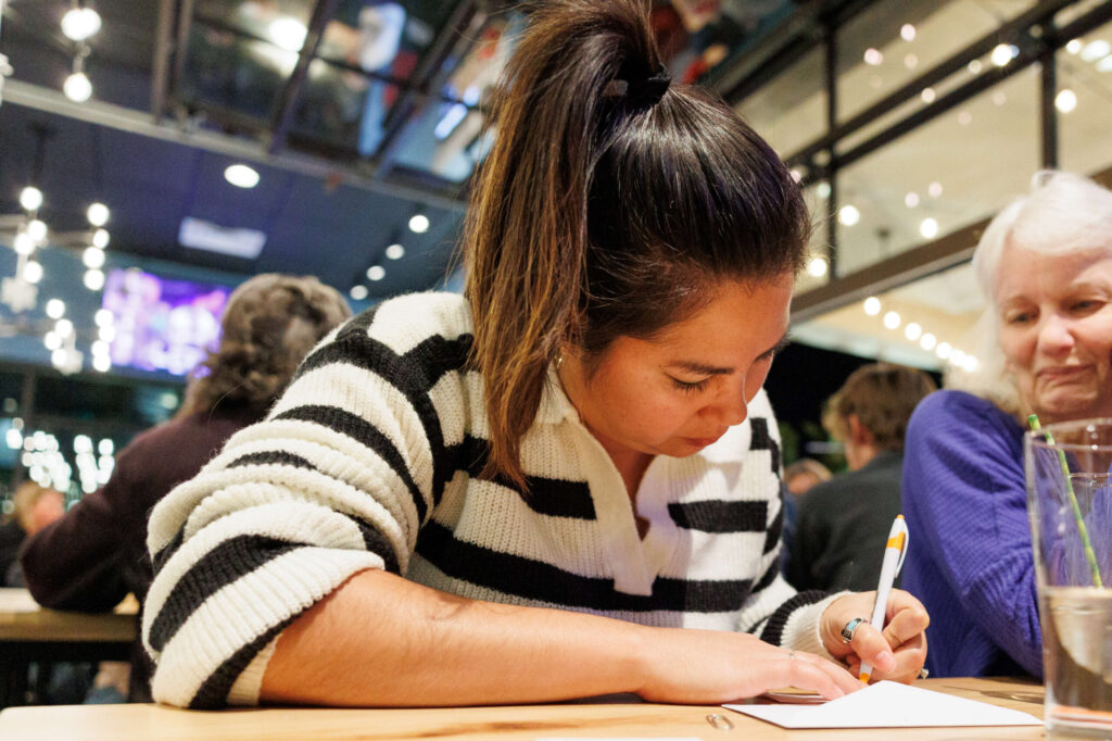 Jessi Meyer writes down their answers for the Redwood Empire Food Bank’s Trivia Night at Barrel Brothers Brewing Kitchen & Cocktails in Windsor on Thursday, Dec. 14, 2023. (Abraham Fuentes / For The Press Democrat)
