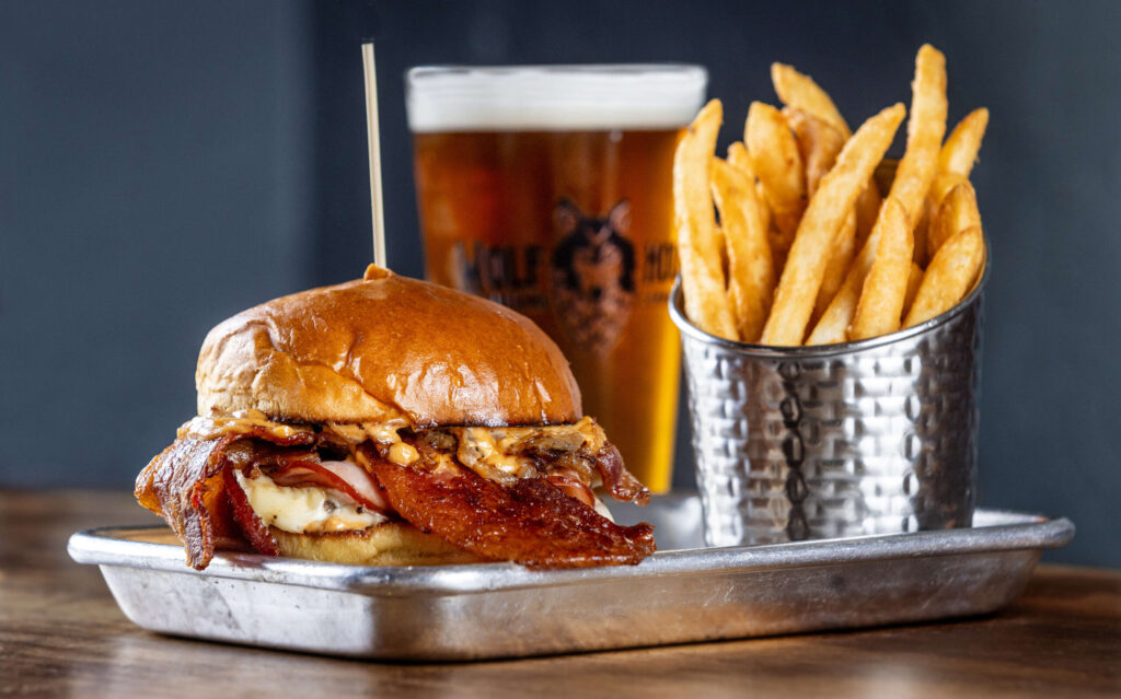 The Porky’s Revenge Burger with smoked ham, bacon, grilled onions, Swiss cheese and chipotle aioli from Wolf House Brewing Friday, March 28, 2025 in Cloverdale. (John Burgess / Press Democrat)