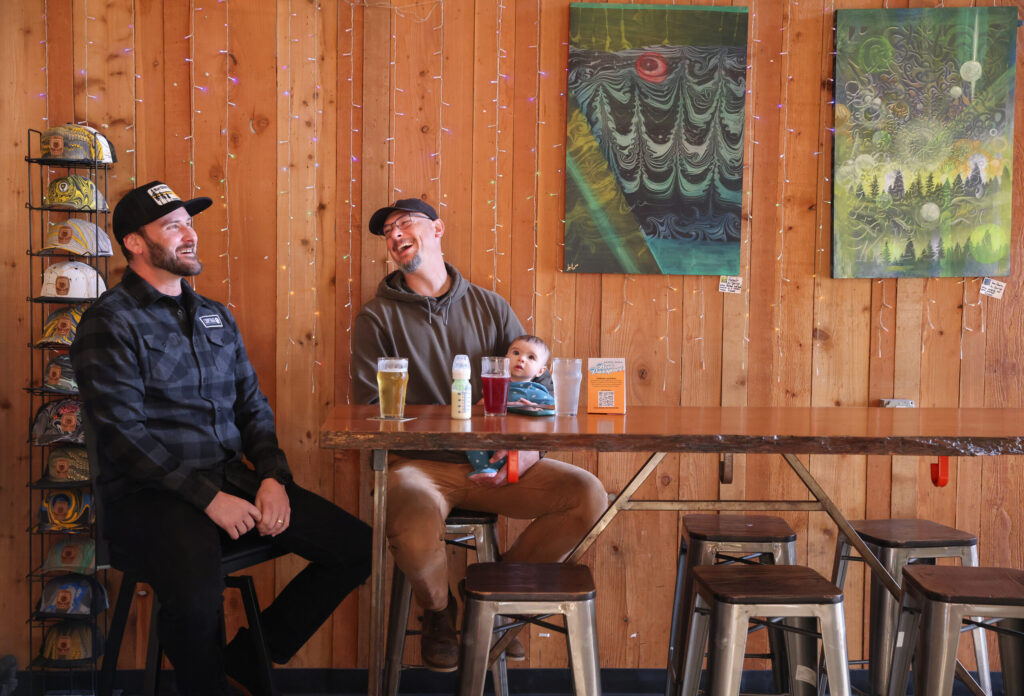 Ryan Hoyt, left, sits down for a beer with Matt Wellen, holding six-month-old Jade, at Cooperage Brewing Company in Santa Rosa on Tuesday, February 3, 2026. (Christopher Chung/The Press Democrat)
