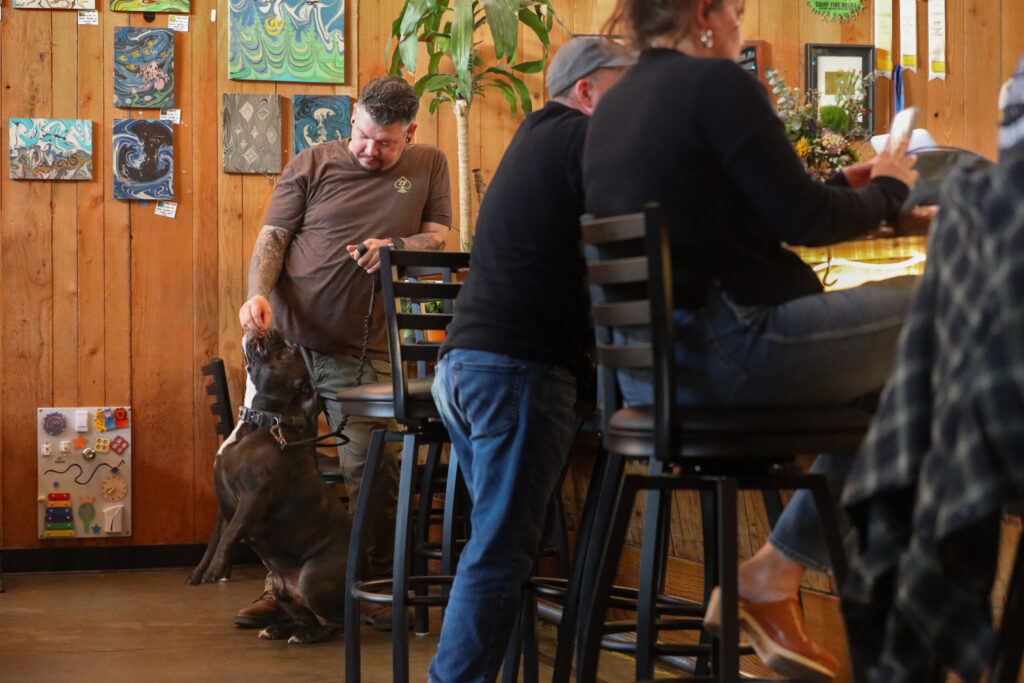 Justin Carter hands Brisket a treat at the bar at Cooperage Brewing Company in Santa Rosa on Tuesday, February 3, 2026. (Christopher Chung/The Press Democrat)