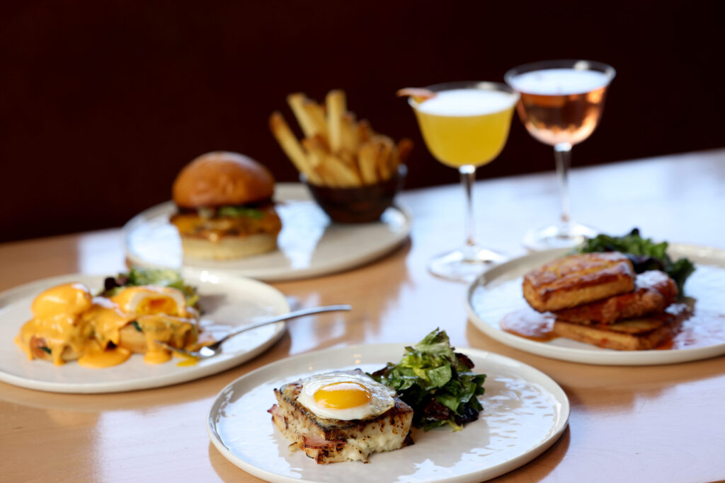 Clockwise from bottom: The Croque Madame, eggs Florentine, Bijou Burger and fries, and the fried chicken and biscuits at Bijou Restaurant in Petaluma Sunday, Feb. 22, 2026. (Beth Schlanker / The Press Democrat)