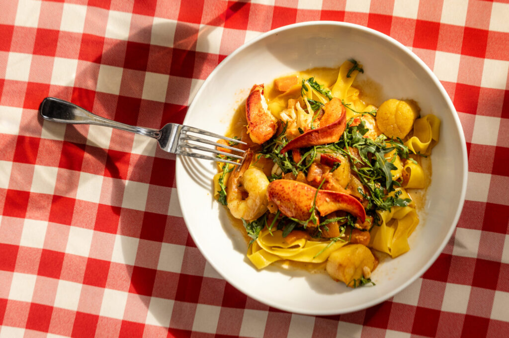 Seafood Pappardelle with scallops, prawns, lobster meat, Calabrian peppers, arugula, fresh tomatoes and a saffron lobster butter sauce from the historic Swiss Hotel Thursday, Feb. 19, 2026 on the square in Sonoma. (John Burgess/The Press Democrat)