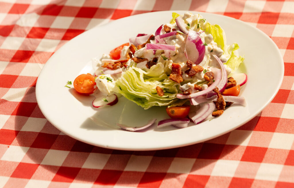 The Chophouse Wedge Salad with iceberg lettuce, radish, onion, tomato, crumbled bacon and creamy blue cheese dressing from the historic Swiss Hotel Thursday, Feb. 19, 2026 on the square in Sonoma. (John Burgess/The Press Democrat)