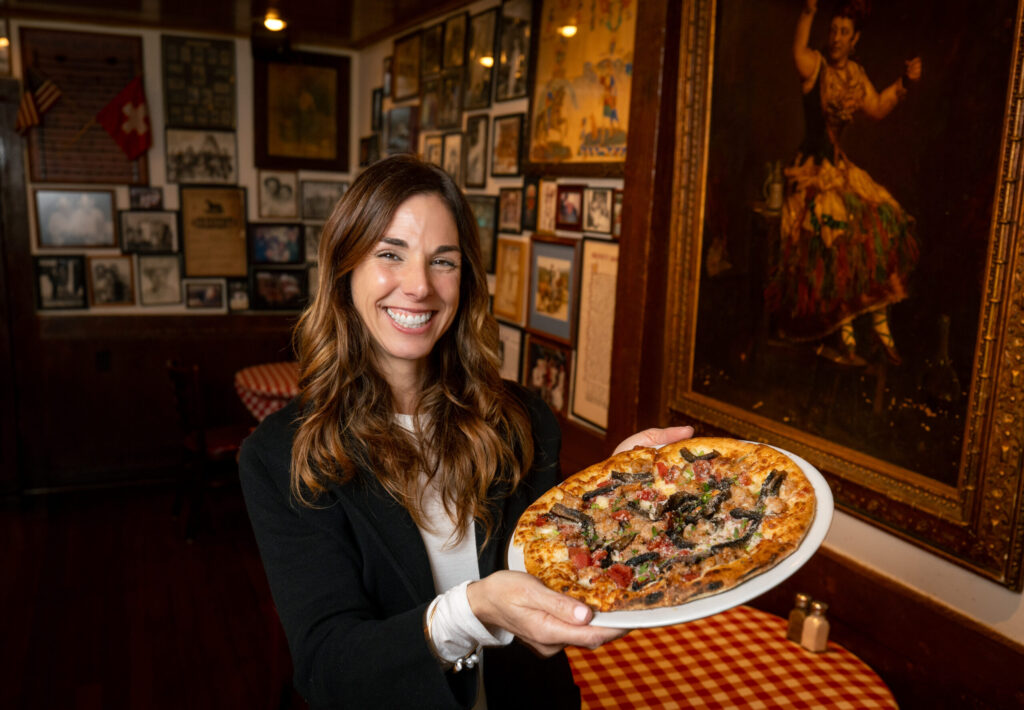 GM Kristin Dunlap Schantz holds a Sweet Sausage & Portobello Mushroom Pizza with mozzarella and roasted tomato in the bar at the historic Swiss Hotel Thursday, Feb. 19, 2026 on the square in Sonoma. (John Burgess/The Press Democrat)