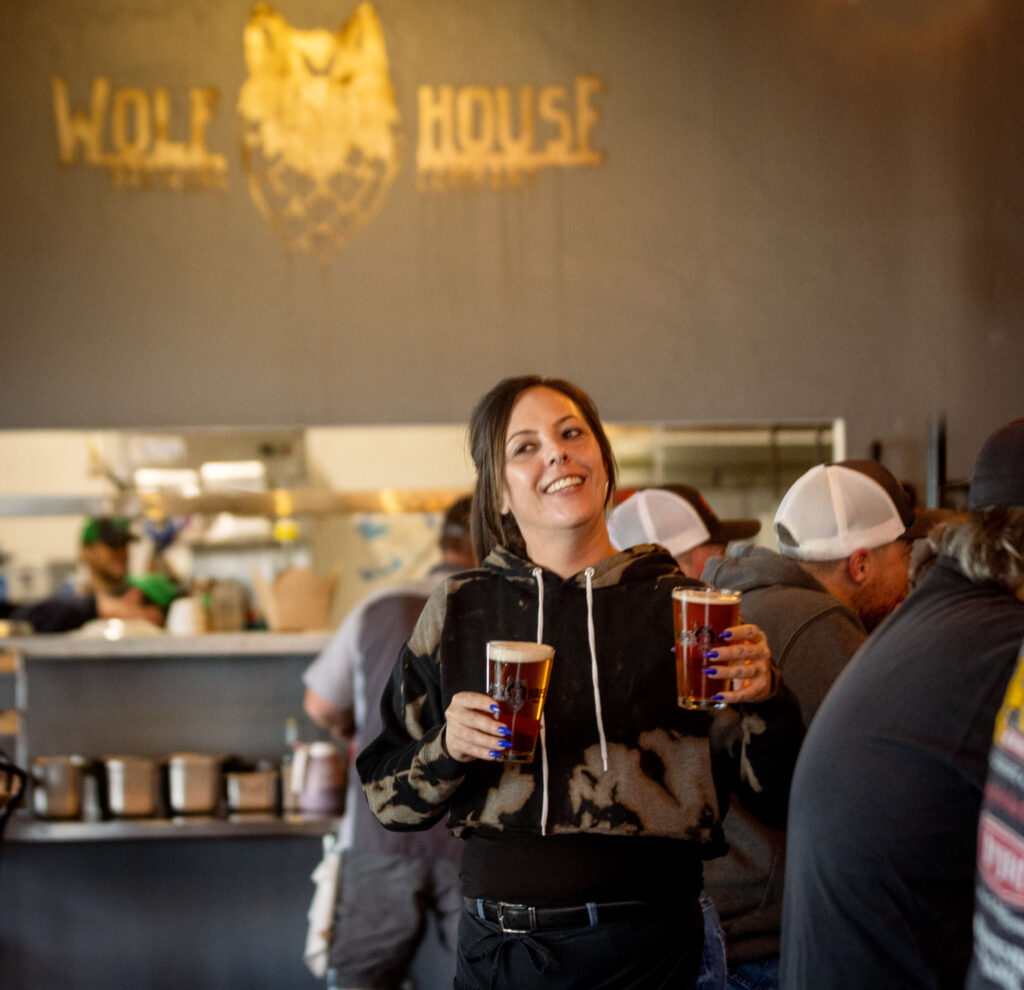 Server Adrienne Tapparo delivers pints for the lunchtime crowd at Wolf House Brewing Friday, March 28, 2025 in Cloverdale. (John Burgess / Press Democrat)